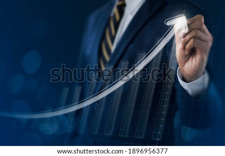 Business growth, boost up business, progress in business or success concept. Businessman is drawing exponential growth graph on dark tone background. Royalty-Free Stock Photo #1896956377