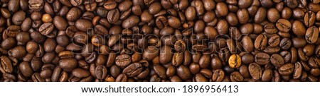 Roasted coffee beans covering the entire picture, creating a nice background.