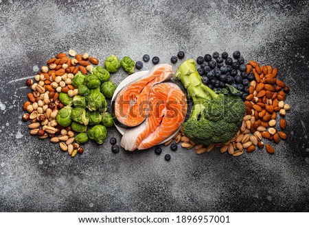 Assorted food for brain health and good memory: fresh salmon, vegetables, nuts, berries on stone background. Healthy fresh products to boost brain power, top view 
 Royalty-Free Stock Photo #1896957001