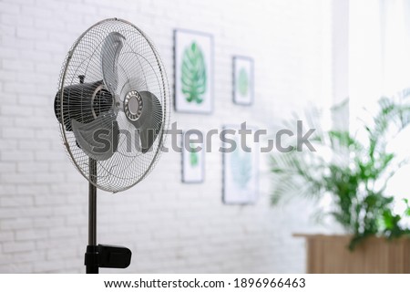 Modern electric fan in room. Space for text Royalty-Free Stock Photo #1896966463