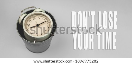 Inspirational and motivational quotes concept, don't lose your time background banner, alarm clock and trash bin