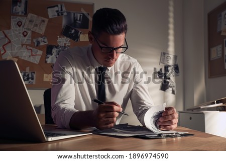 Detective working at desk in his office