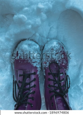 stylish purple boots with black laces and overheat part in the snow. winter concept.  against the background of snow.  top view, flatlay