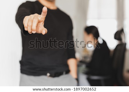 Businessman is pointing finger with woman working in background