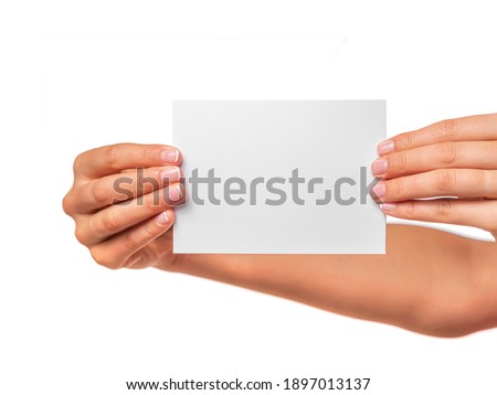 Female hand holds a white card isolated on a white background.