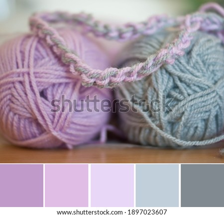 Close up colorful yarn texture background, violet lavender pink and gray strains. Shallow depth of focus. Color palette swatches, fresh trendy combination of colors for styling, pastel nuances.
