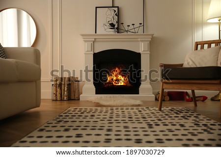 Modern fireplace with burning wood in room. Interior design