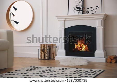 Modern fireplace with burning wood in room. Interior design Royalty-Free Stock Photo #1897030738