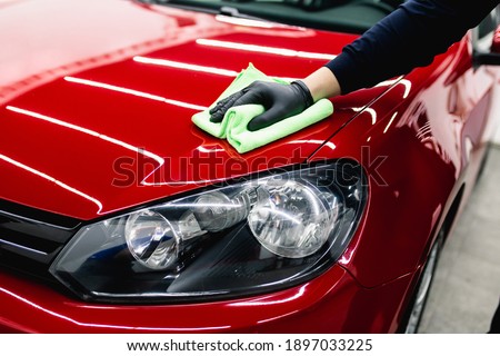 A man cleaning car with cloth, car detailing (or valeting) concept. Selective focus.  Royalty-Free Stock Photo #1897033225