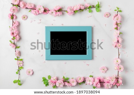 Blank photo frame with pink flowers on white marble background. Womens Day, Mothers Day, Valentines Day, Wedding concept. flat lay, mock up. top view with copy space
