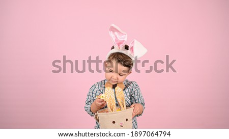 Child and easter, on pink background. High quality photo