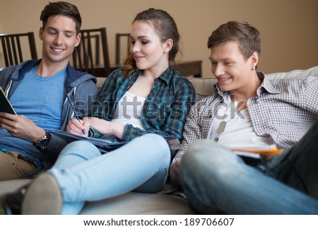 Three young students preparing for exams in apartment interior 