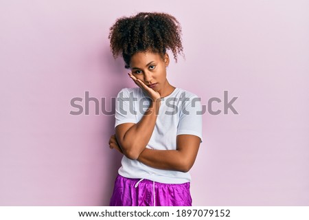 Beautiful african american woman with afro hair wearing sportswear thinking looking tired and bored with depression problems with crossed arms. 