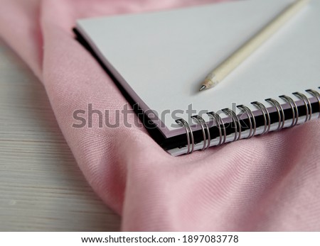 Empty spiral notebook and pencil on pink scarf, sketch book close up, feminine styled stock photo for blog post, writing, art, design concept.