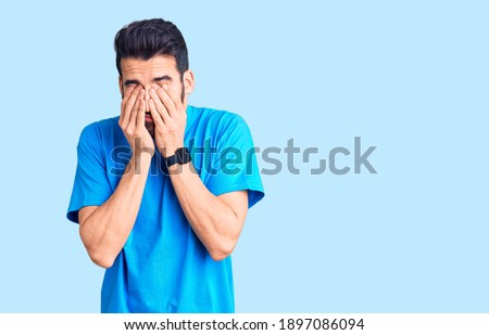 Young handsome man with beard wearing casual t-shirt rubbing eyes for fatigue and headache, sleepy and tired expression. vision problem 