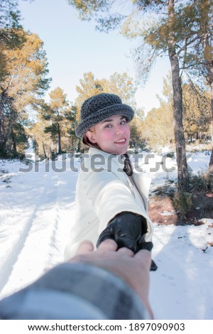  Outdoor close-up photo of caucasian female model with romantic smile laughing while posing on snow background with hands held her boyfriend.chilling in park in winter day.