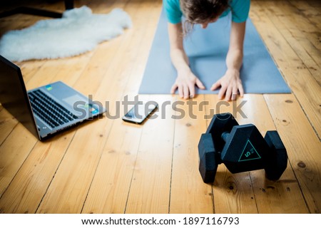 woman doing exercise at home focus on dumbells