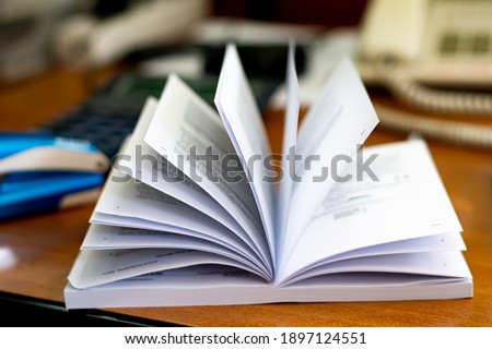 Soft focus to paper pages of opened book with blurred background of office table. Education concept. Symbol of knowledge