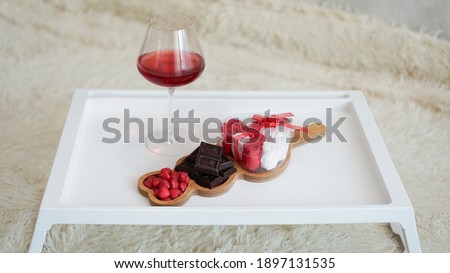 Breakfast for girlfriend. Valentines Day Morning. Wine and sweets on a white tray. Breakfast in bed.