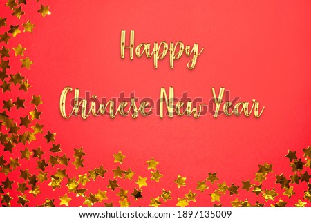 Happy Chinese New Year text with golden star confetti on red paper background. Flat lay and top view, template for copy space
