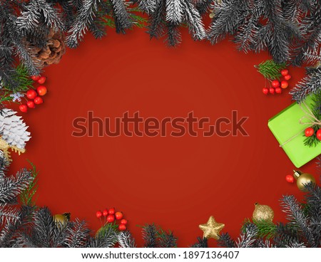 Christmas frame with gift box, paper decorations, spruce branches and berries on red background.
