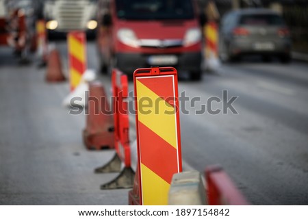 Shallow depth of field (selective focus) with a road attention sign on a heavy traffic road.