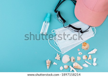 Vacation during COVID-19: Protection mask, cap, swimming goggles, different kinds of seashells, corals.
