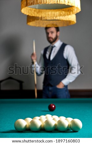 close-up photo of billiards balls on table, focus on white balls, handsome guy in the background