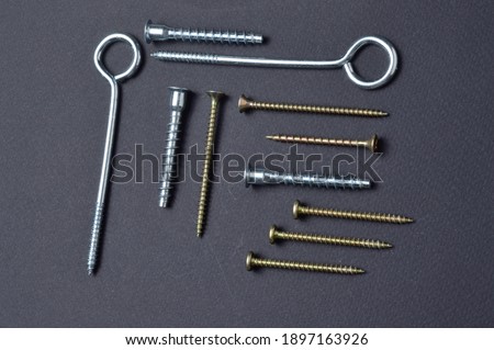 self-tapping screws and various fittings are laid out on a dark background. close-up.