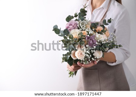 Florist holding beautiful wedding bouquet on white background, closeup Royalty-Free Stock Photo #1897171447