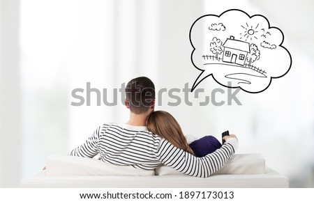 Young couple sitting on the sofa and thinking for house Royalty-Free Stock Photo #1897173013