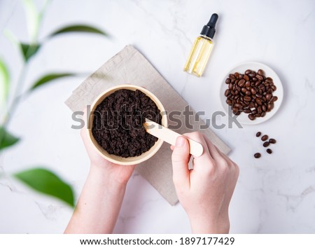 Home skin care. A young woman mix a homemade coffee scab with oil from recycled capsules. Top view and flat lay