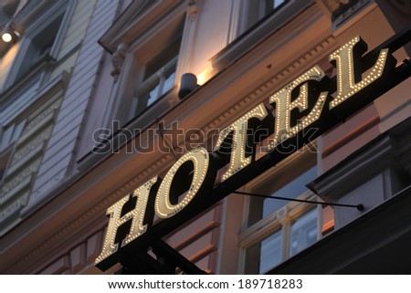 Illuminated hotel signboard on the wall of building