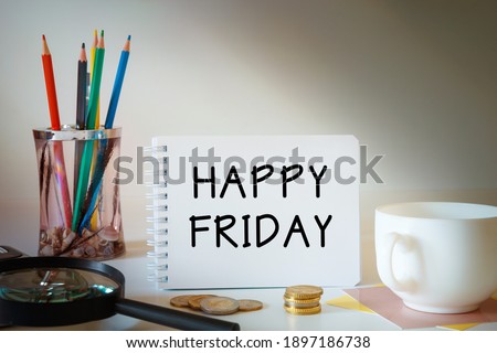 Notebook with the text - HAPPY FRIDAY - on the office table among the stationery.
