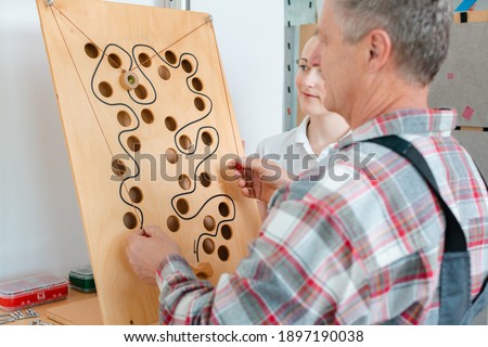 Man with therapist in occupational therapy testing his dexterity on a game board Royalty-Free Stock Photo #1897190038