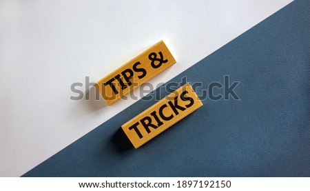 Tips and tricks symbol. Wooden blocks with words 'Tips and tricks'. Beautiful white and blue background. Business, tips and tricks concept. Copy space.