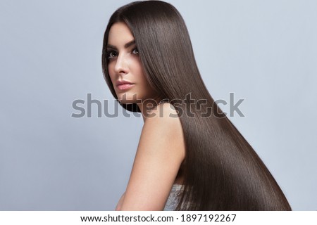 Beautiful brown-haired girl with a perfectly smooth hair, and classic make-up. Beauty face and hair. Picture taken in the studio. Royalty-Free Stock Photo #1897192267
