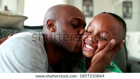Father and son love and affection. Parent kissing and hugging little boy child. Mixed race African ethnicity Royalty-Free Stock Photo #1897210864