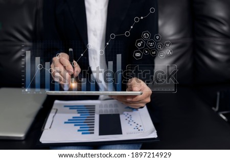 Double exposure of businesswoman working on digital tablet with digital marketing virtual chart, Abstract icon, Business finance technology concept. blurred background.