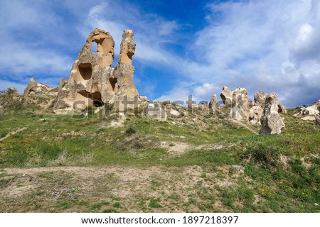 Fantastic rock formations with ruins of many cave churches in a valley near Goreme, Cappadocia, Turkey.  Spring sunny day, beautiful blue and white sky