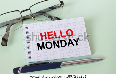 Text Hello Monday on business card with eyeglasses and pen. Concept photo