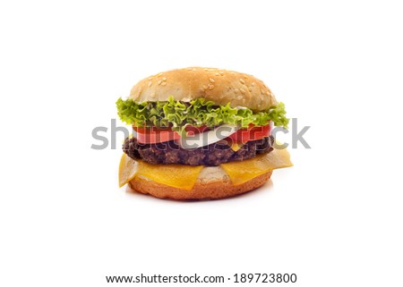 Delicious cheeseburger stacked high with a juicy beef patty, cheese, fresh lettuce, onion and tomato on a fresh bun with sesame seed standing on dark blue on a white background