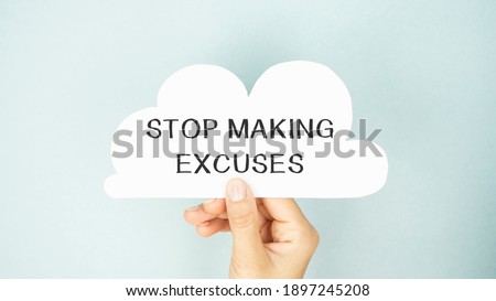 Closeup on businessman holding a card with text STOP MAKING EXCUSES, business concept image with soft focus background and vintage tone