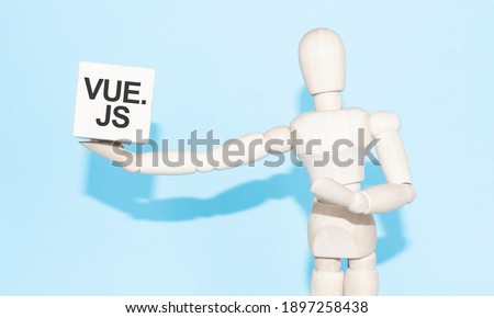 Business and design concept - wooden mannequin with surreal wood cube Javascript VUE JS. the symbol of leadership, communication and success Royalty-Free Stock Photo #1897258438