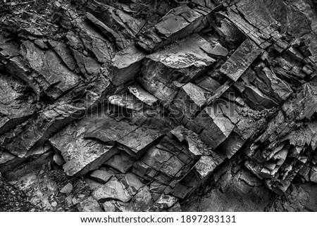 Texture, background layers and cracks in sedimentary rock on cliff face. Cliff of rock mountain. Rock slate in the mountain. Seamless abstract background. Cracks and layers of sandstone. Royalty-Free Stock Photo #1897283131
