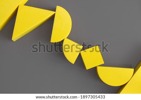 Flat lay composition of yellow geometric shapes on gray background. Colors of the Year 2021 Illuminating and Ultimate gray. Minimalism concept.