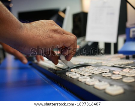 hand on dissolve of switcher buttons in studio TV station,Television Broadcast.