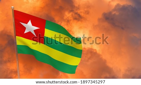 Togo flag on pole. Dramatic background. National flag of Togo