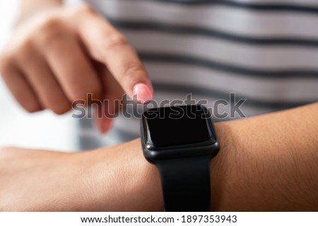 Hand press a button on a smartwatch screen.