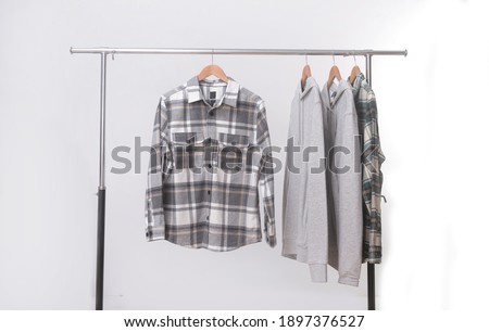 plaid shirt checkered shirt closeup with gray hoodie hanging on hangers